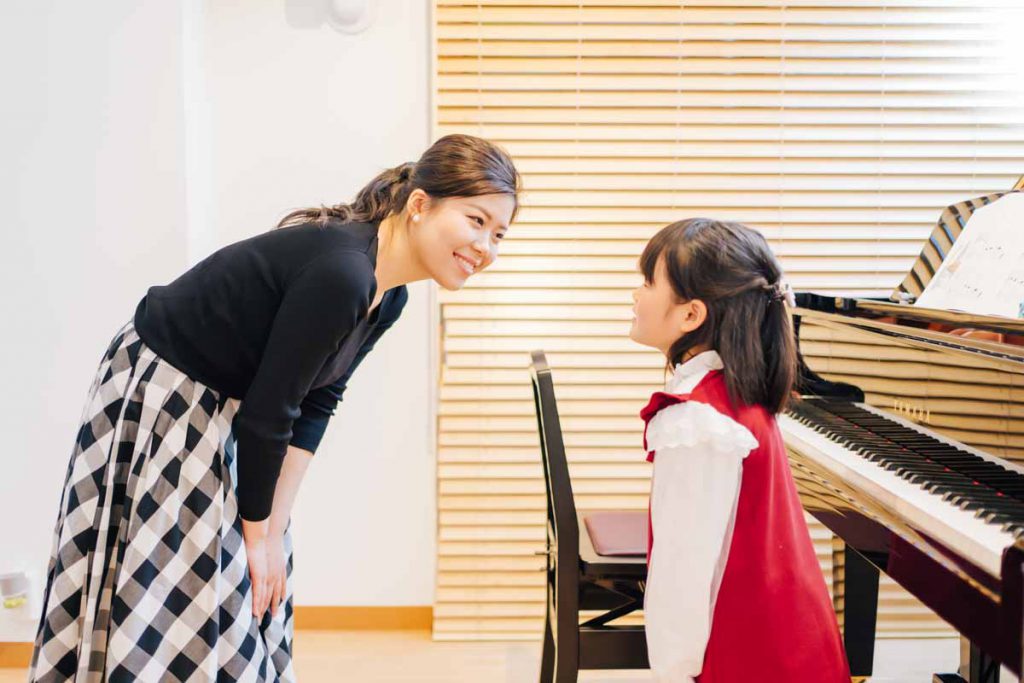東京ルクスピアノ教室の無料体験レッスン風景 子どもと講師がグランドピアノの前で挨拶をする様子｜東京のピアノ教室 東京ルクスピアノ教室